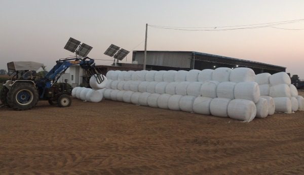 Tractor stacking round bales